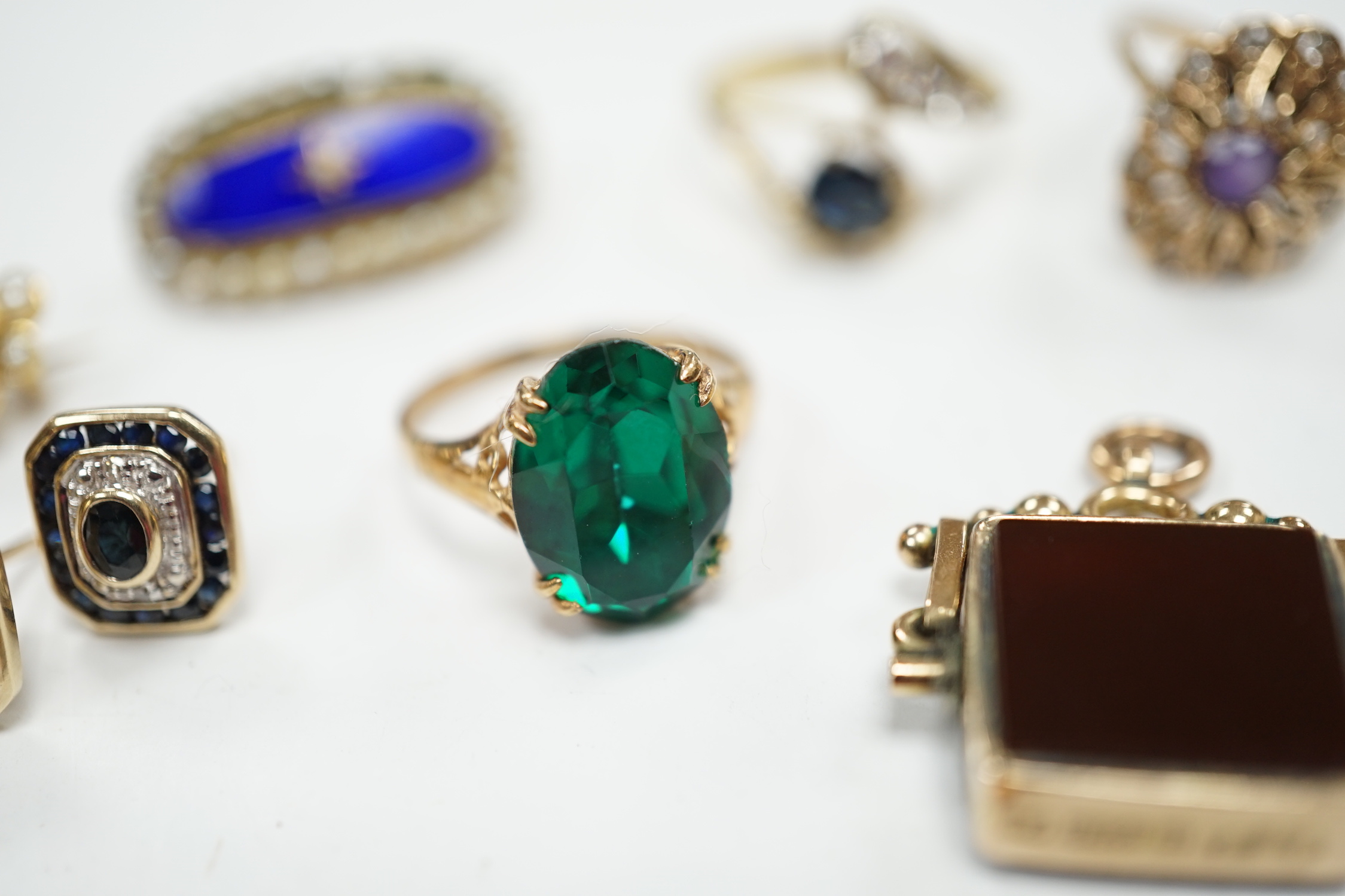 A 750 yellow metal, single stone sapphire and three stone diamond set crossover ring, size, three other yellow metal and gem set rings including a continental 875 white metal and 585 yellow metal, synthetic sapphire or s